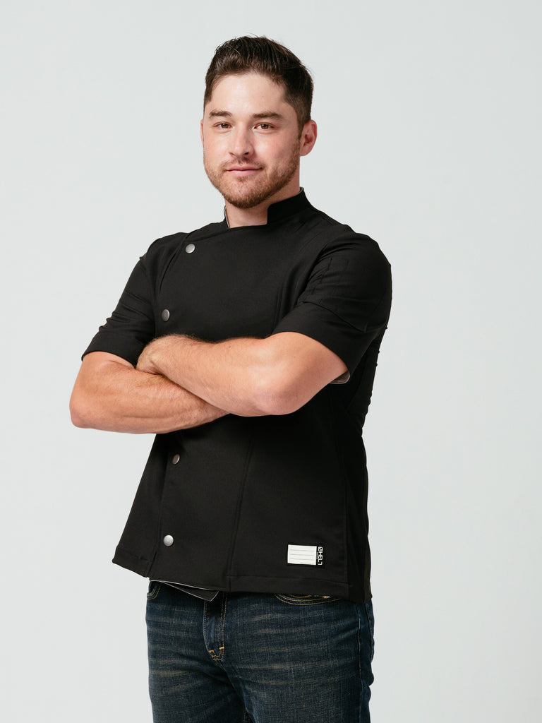 Man posing with his arms crossed modeling Helt Studio's Hipster Chef Coat Noir.