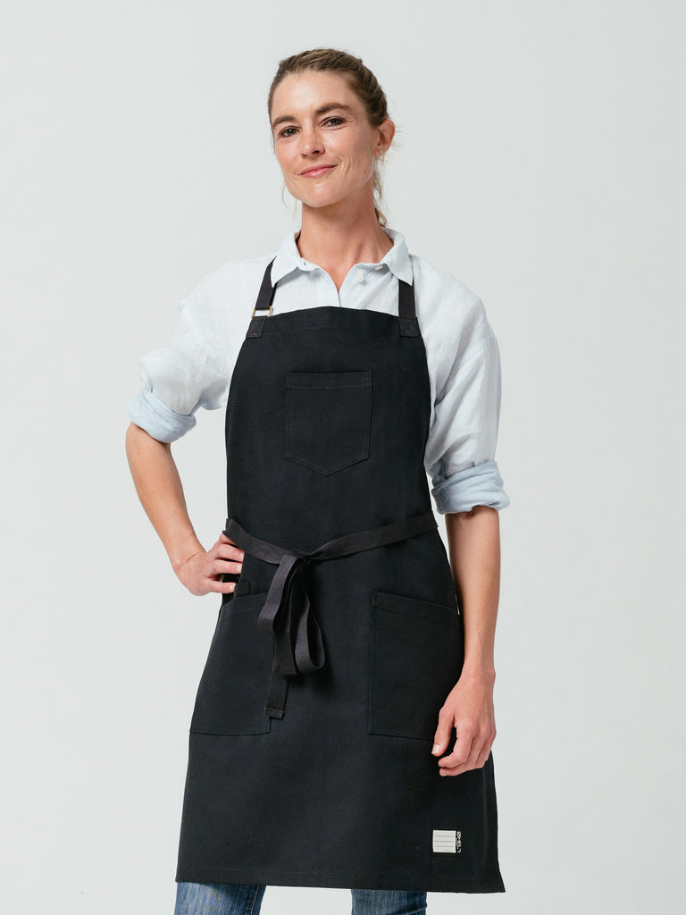 Woman with hand on her hip modeling Helt Studio's Raven Canvas Apron.