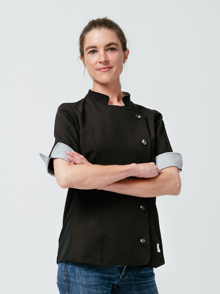 Woman posing with arms crossed modeling Helt's Stephany Chef Coat in black.