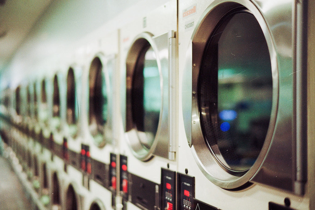 Row of washing machines with red buttons