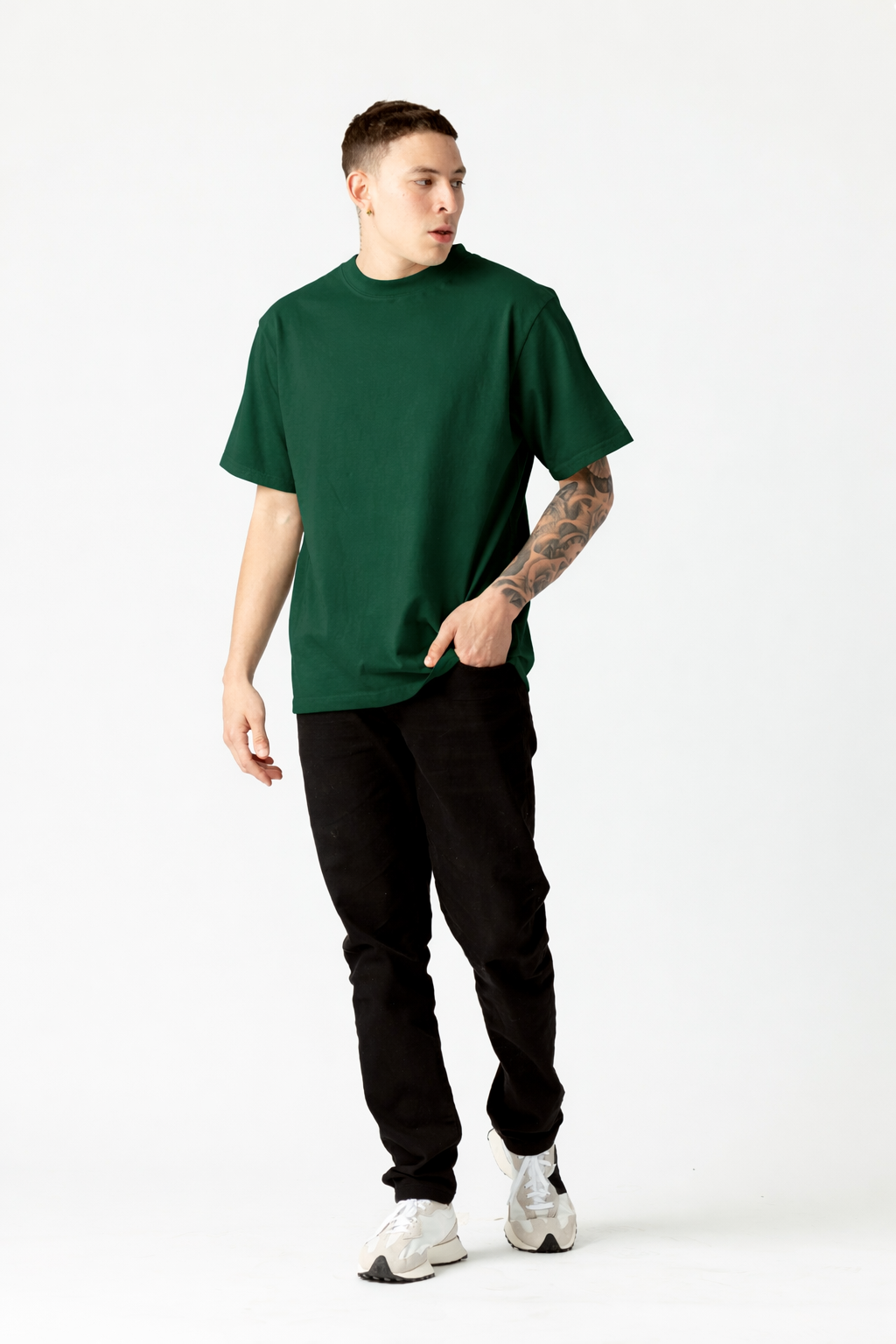 Person wearing a green t-shirt and black pants on a white background