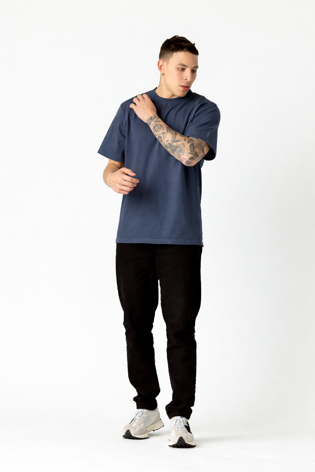 Man wearing a blue t-shirt and black pants on a white background