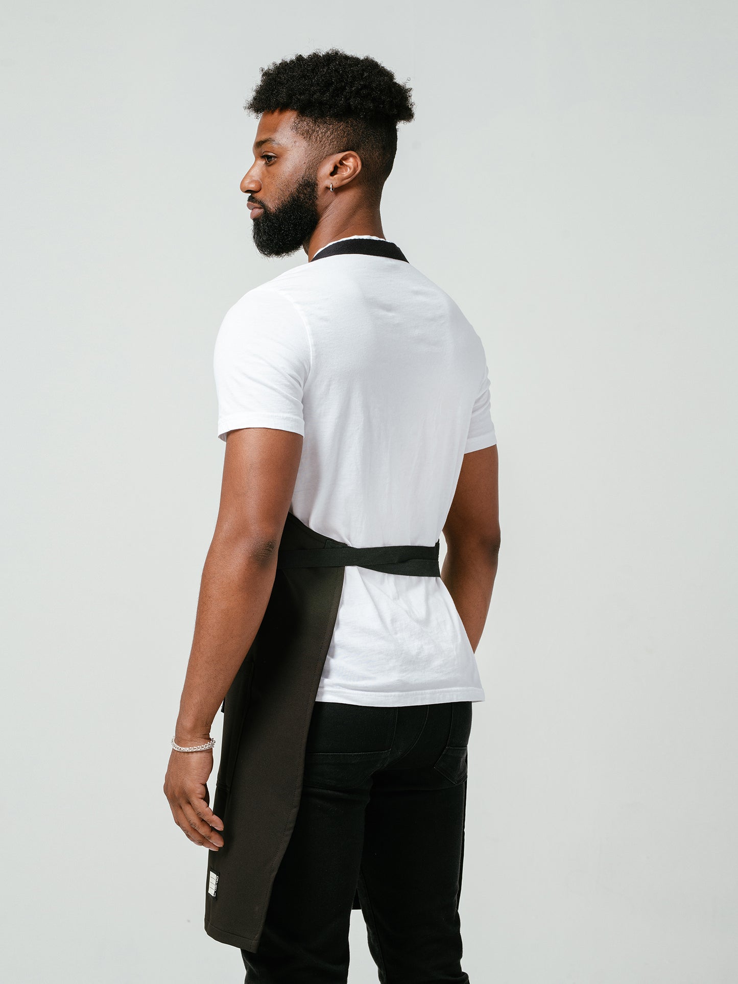Man modeling the back of Helt Studio's Noir CrewTech Apron.