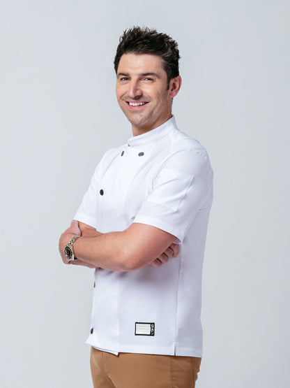 Man posing with his arms crossed modeling Helt Studio's Midtown Chef Coat in white.