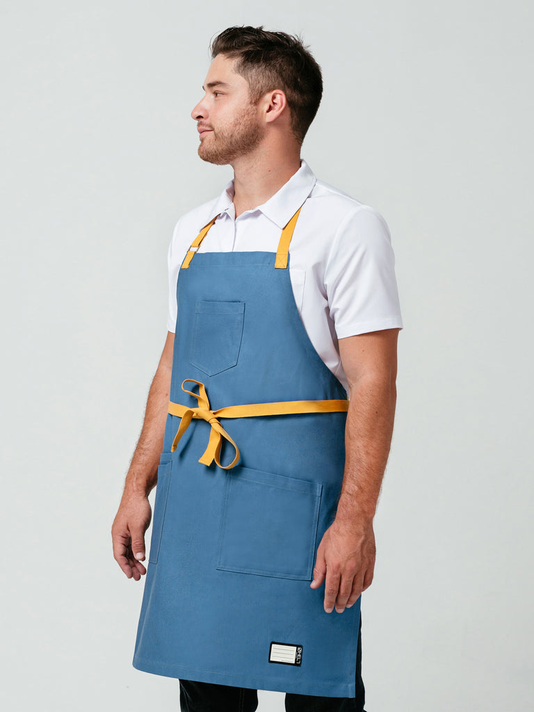 Man posing looking away from camera modeling Helt Studio's Pot of Gold Bib Apron.