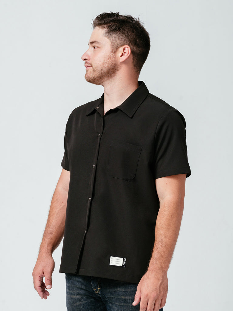 Man looking away from camera modeling Helt Studio's Utility Work Shirt in black.