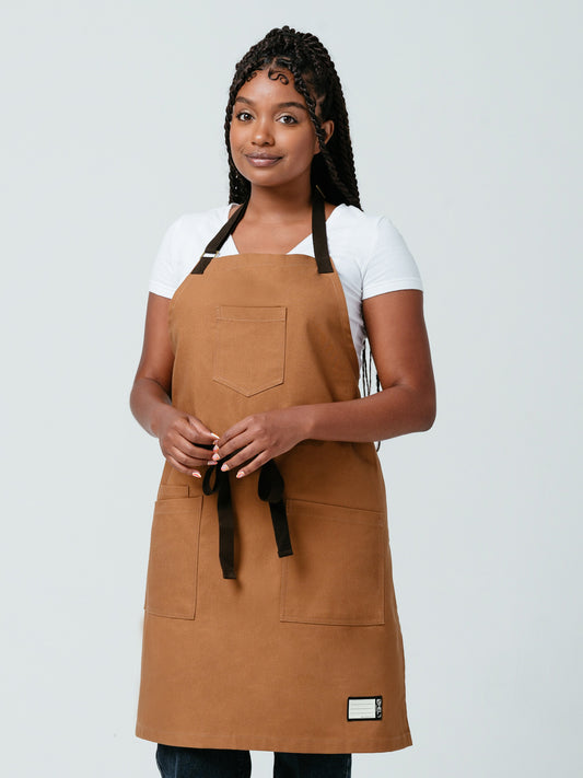 Woman modeling Helt Studio's Ranch Tan DWR Bib Apron.