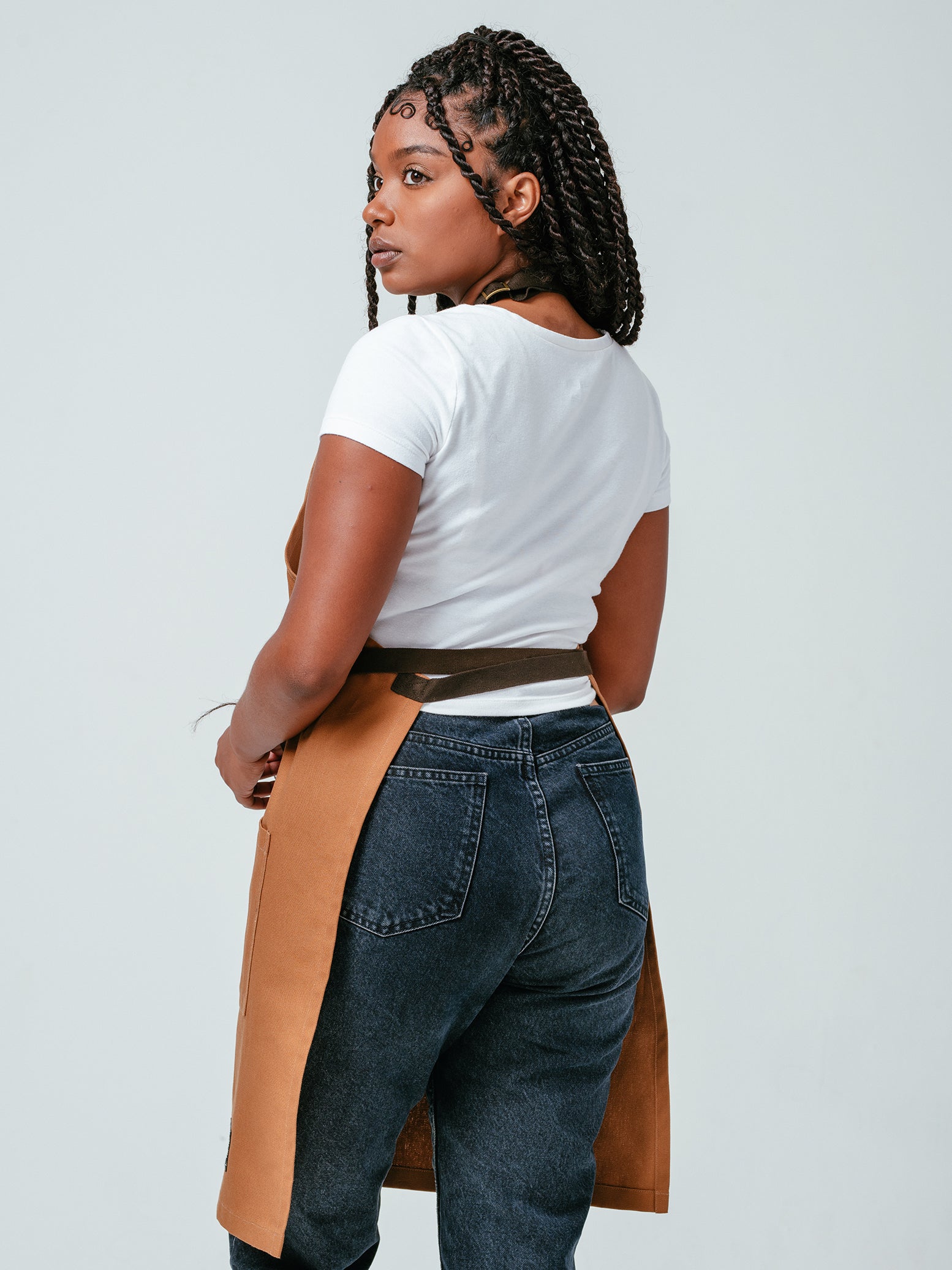 Woman modeling the back of Helt Studio's Ranch Tan DWR Bib Apron.