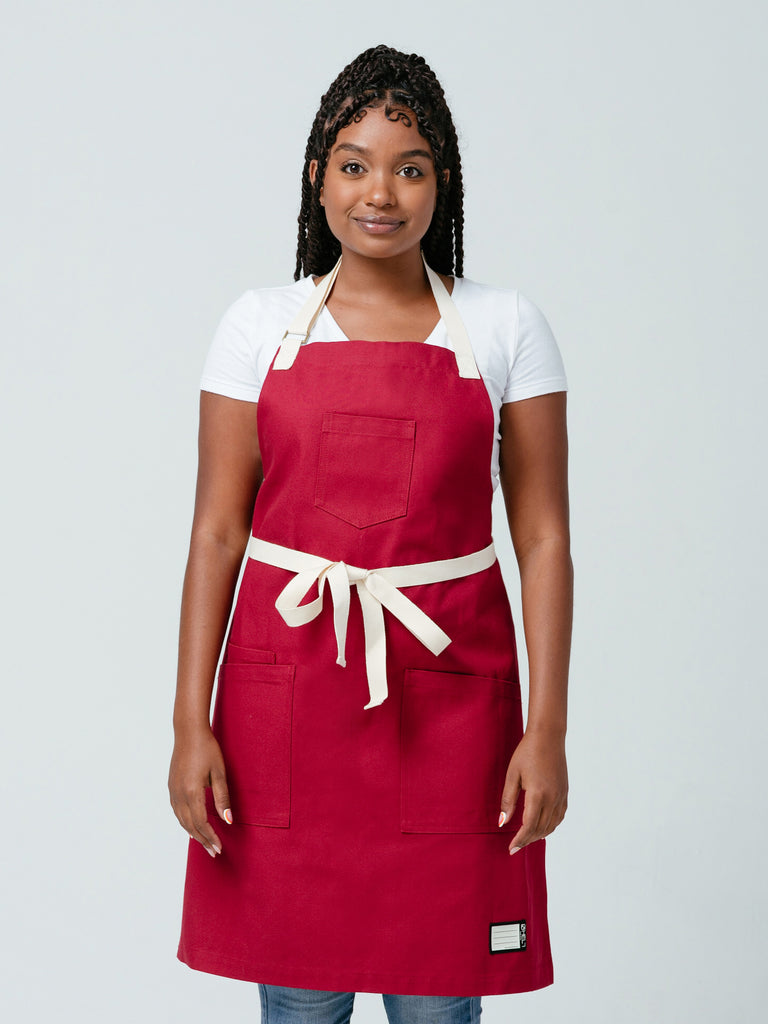 Woman modeling Helt Studio's Burgundy Red Bib Apron.