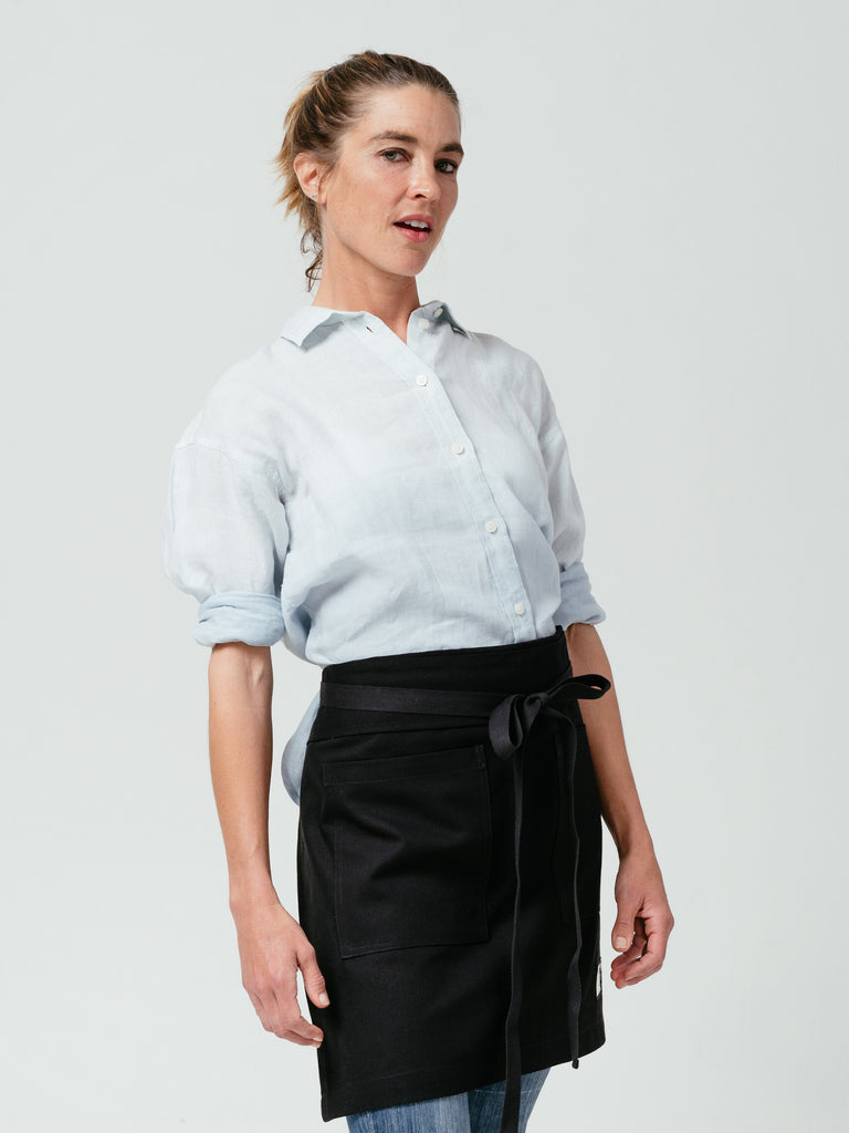 Woman leaning back while modeling Helt Studio's Raven DWR Bistro Apron.