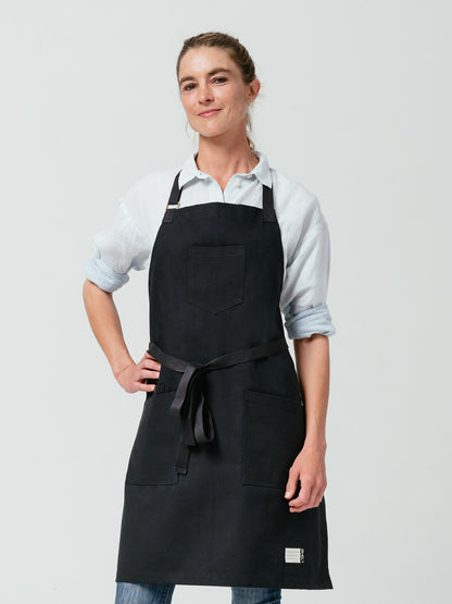 Woman with hand on her hip modeling Helt Studio's Raven Canvas Apron.