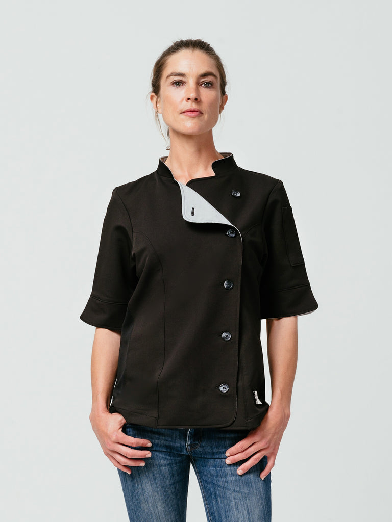 Woman with hands on her jeans modeling Helt's Stephany Chef Coat in black.