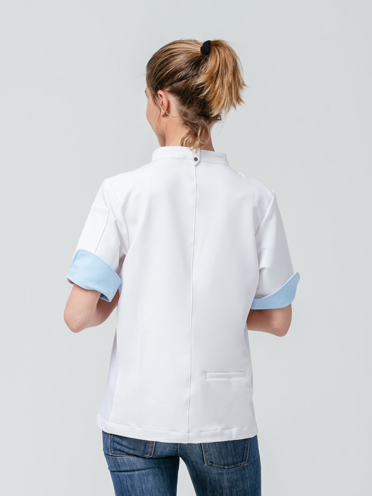 Woman modeling the back of the Stephany Chef Coat in white.