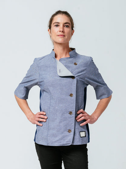 Woman with hands on her hips modeling Helt Studio's Stephany Chambray Chef Coat.