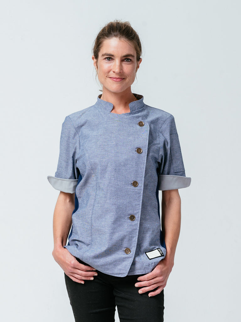 Woman with hands on her jeans modeling Helt Studio's Stephany Chambray Chef Coat.
